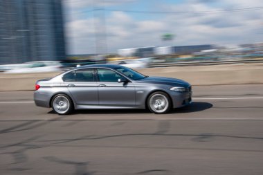 Ukrayna, Kyiv - 26 Nisan 2021: Gri BMW 5 Serisi arabası yolda ilerliyor.  