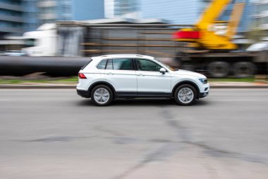 Ukrayna, Kyiv - 26 Nisan 2021: Beyaz Volkswagen Tiguan arabası yolda ilerliyor.  