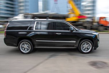 Ukrayna, Kyiv - 26 Nisan 2021: Siyah Cadillac Escalade arabası sokakta hareket ediyor. Yazı