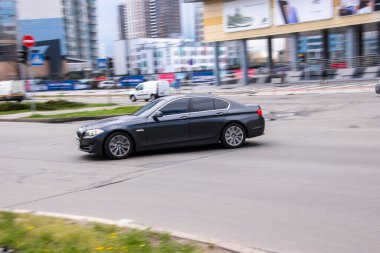 Ukrayna, Kyiv - 26 Nisan 2021: Siyah BMW 5 Serisi araba yolda ilerliyor. 