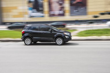 Ukraine, Kyiv - 26 April 2021: Black Ford EcoSport car moving on the street. 