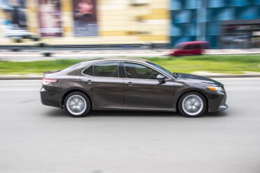 Ukrayna, Kyiv - 26 Nisan 2021: Sokakta ilerleyen kahverengi Toyota Camry arabası. Yazı