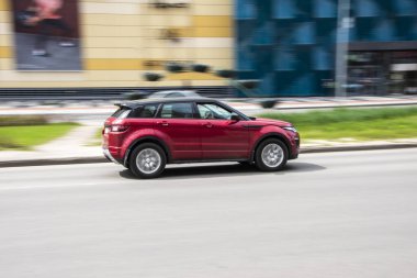 Ukrayna, Kyiv - 26 Nisan 2021: Kırmızı Land Rover Range Evoque aracı caddede ilerliyor. Yazı