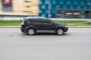 Ukrayna, Kyiv - 26 Nisan 2021: Siyah Mitsubishi Outlander arabası sokakta hareket ediyor. Yazı