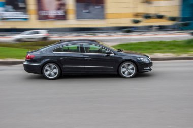 Ukrayna, Kyiv - 26 Nisan 2021: Siyah Volkswagen Passat CC aracı sokakta hareket ediyor. Yazı
