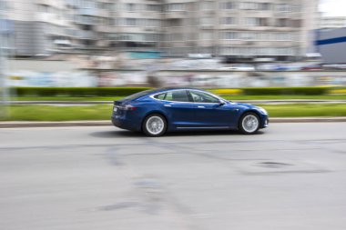 Ukrayna, Kyiv - 26 Nisan 2021: Mavi TESLA Model S arabası sokakta hareket ediyor. Yazı