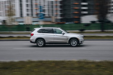 Ukrayna, Kyiv - 26 Nisan 2021: Gümüş renkli BMW X5 arabası sokakta hareket ediyor. Yazı
