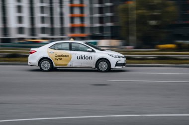 Ukrayna, Kyiv - 26 Nisan 2021: Beyaz Toyota Corolla Uklon arabası yolda ilerliyor. Yazı