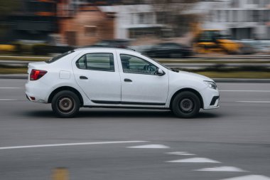 Ukrayna, Kyiv - 26 Nisan 2021: Beyaz Renault Logan arabası yolda ilerliyor. Yazı