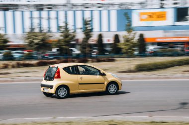Ukrayna, Kyiv - 13 Mayıs 2021: Sarı Peugeot 107 numaralı araba sokakta hareket ediyor. Yazı