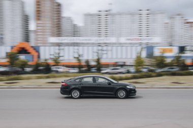 Ukrayna, Kyiv - 13 Mayıs 2021: Siyah Ford Mondeo arabası sokakta hareket ediyor. Yazı
