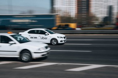 Ukraine, Kyiv - 29 April 2021: White Ford Mondeo Uber Taxi car moving on the street. Editorial