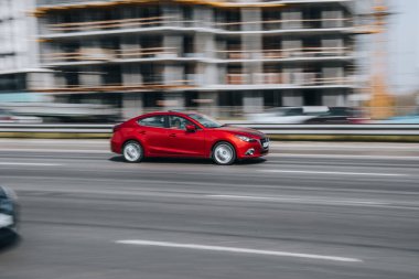 Ukrayna, Kyiv - 29 Nisan 2021: Kırmızı MAZDA 3 aracı yolda ilerliyor. 