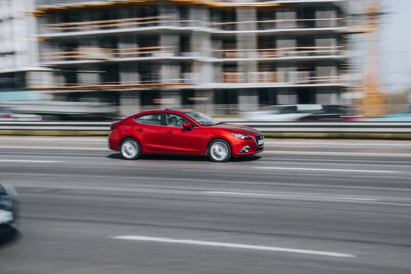 Ukrayna, Kyiv - 29 Nisan 2021: Kırmızı MAZDA 3 aracı yolda ilerliyor. 