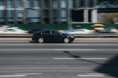 Ukrayna, Kyiv - 29 Nisan 2021: Siyah KIA Magentis arabası sokakta hareket ediyor. 