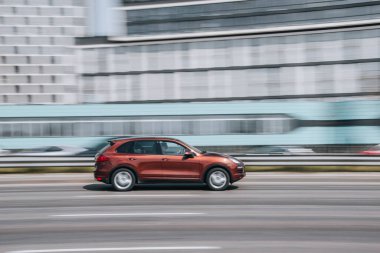Ukrayna, Kyiv - 29 Nisan 2021: Kırmızı Porsche Cayenne arabası yolda ilerliyor. 