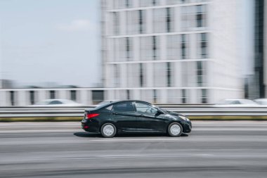 Ukrayna, Kyiv - 29 Nisan 2021: Siyah Nissan Versa arabası sokakta hareket ediyor.  