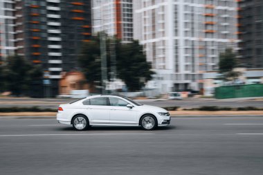 Ukrayna, Kyiv - 27 Haziran 2021: Beyaz Volkswagen Passat aracı sokakta hareket ediyor.  
