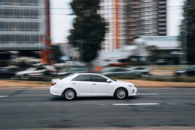 Ukrayna, Kyiv - 29 Nisan 2021: Beyaz Toyota Camry arabası yolda ilerliyor. 