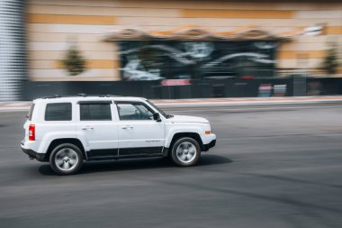 Ukrayna, Kyiv - 27 Haziran 2021: Beyaz Jeep Patriot arabası yolda ilerliyor. Yazı