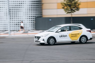 Ukrayna, Kyiv - 27 Haziran 2021: Beyaz Taksi Uklon arabası yolda ilerliyor. Yazı