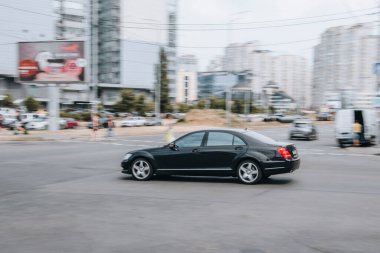Ukrayna, Kyiv - 27 Haziran 2021: Siyah Mercedes-Benz S-Sınıfı araba yolda ilerliyor. Yazı