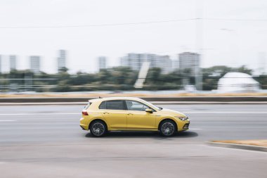 Ukrayna, Kyiv - 27 Haziran 2021: Sarı Volkswagen arabası sokakta ilerliyor.  
