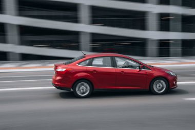 Ukrayna, Kyiv - 27 Haziran 2021: Kırmızı Ford Focus aracı sokakta hareket ediyor.  