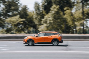 Ukrayna, Kyiv - 27 Haziran 2021: Turuncu Peugeot 2008 arabası sokakta hareket ediyor.  