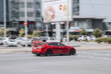Ukrayna, Kyiv - 27 Haziran 2021: Kırmızı TESLA Model S arabası yolda ilerliyor. 