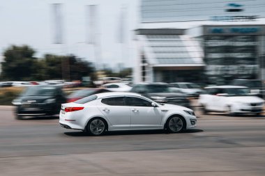 Ukrayna, Kyiv - 27 Haziran 2021: Beyaz KIA Optima arabası yolda ilerliyor. 