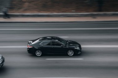Ukrayna, Kyiv - 16 Temmuz 2021: Siyah Toyota Camry arabası sokakta hareket ediyor. 