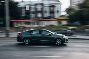 Ukrayna, Kyiv - 16 Temmuz 2021: Gri Ford Fusion (Kuzey Amerika) arabası sokakta hareket ediyor. 