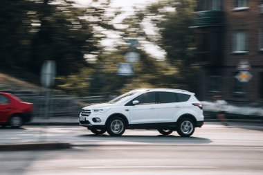 Ukrayna, Kyiv - 16 Temmuz 2021: Beyaz Ford Kuga arabası sokakta hareket ediyor. 