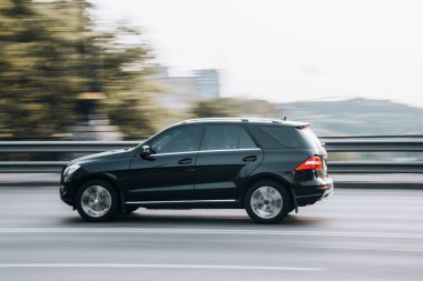 Ukrayna, Kyiv - 16 Temmuz 2021: Siyah Mercedes-Benz M-sınıfı araba yolda ilerliyor. 