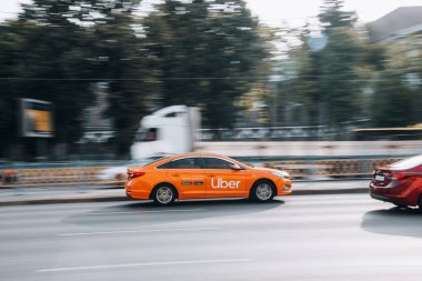 Ukraine, Kyiv - 16 July 2021: Orange Hyundai Sonata Taxi Uber car moving on the street. Editorial