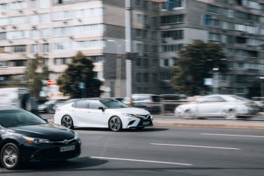 Ukrayna, Kyiv - 16 Temmuz 2021: Beyaz Toyota Camry arabası sokakta hareket ediyor. 