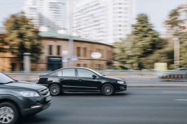 Ukrayna, Kyiv - 16 Temmuz 2021: Siyah Volkswagen Passat aracı sokakta hareket ediyor. 