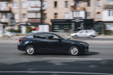 Ukrayna, Kyiv - 16 Temmuz 2021: Siyah MAZDA 3 aracı sokakta hareket ediyor. Yazı