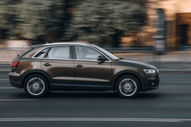 Ukrayna, Kyiv - 16 Temmuz 2021: Caddede hareket eden kahverengi Audi Q3 arabası. Yazı
