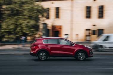 Ukrayna, Kyiv - 16 Temmuz 2021: Kırmızı KIA Spor Araba sokakta hareket ediyor. Yazı