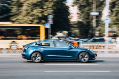 Ukrayna, Kyiv - 16 Temmuz 2021: Mavi TESLA Modeli 3 yolda ilerliyor. Yazı