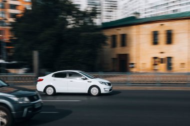 Ukrayna, Kyiv - 16 Temmuz 2021: Beyaz KIA Rio arabası yolda ilerliyor. 