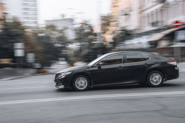 Ukrayna, Kyiv - 2 Haziran 2021: Siyah Toyota Camry arabası sokakta hareket ediyor