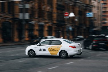 Ukrayna, Kyiv - 2 Haziran 2021: Beyaz Citroen C-Elysee Taksi Uklon aracı caddede ilerliyor.