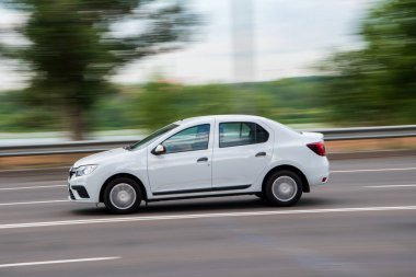 Ukrayna, Kyiv - 29 Temmuz 2021: Beyaz Renault Logan 'ın arabası yolda ilerliyor.