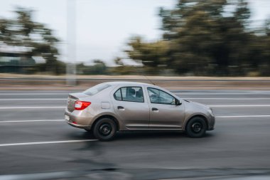 Ukrayna, Kyiv - 29 Temmuz 2021: Bej renkli Renault Logan arabası yolda ilerliyor. Yazı