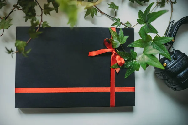 Caja Regalo Negra Con Cinta Roja Auriculares Fotos de stock libres de derechos