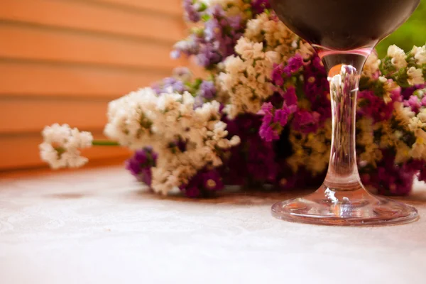 红酒和花在户外的桌子上的玻璃 — 图库照片
