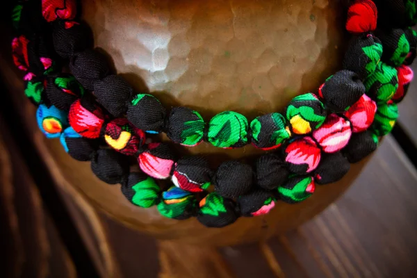 Фрагмент ткани ожерелье из красочных цветов с мета — стоковое фото